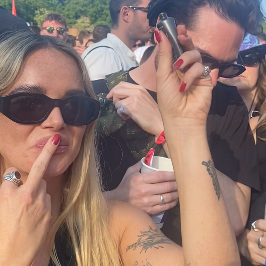 Girl applying Dr.Lipp Nipple Balm whilst dancing at festival