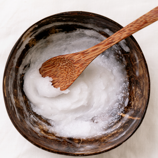Coconut oil in wooden bowl with wooden spoon